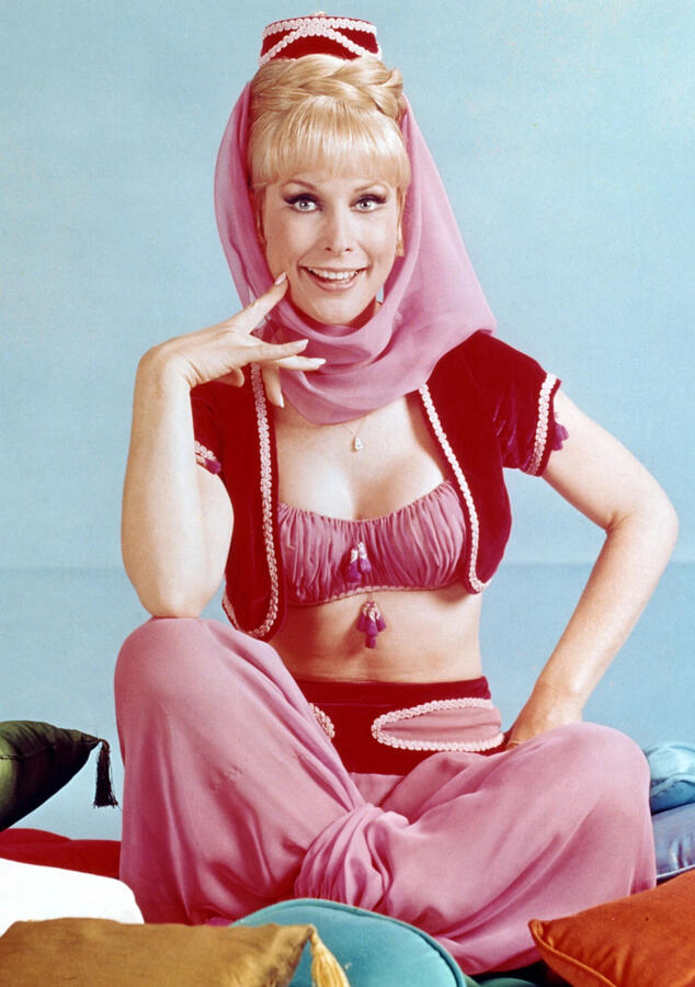 Jeannie A photograph of Jeannie from "I Dream of Jeannie." This image features a white woman wearing a headscarf that does not cover her hair and a fetishized "belly dancer" outfit in pink.