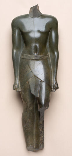 A broken figurine wearing a shendyt.